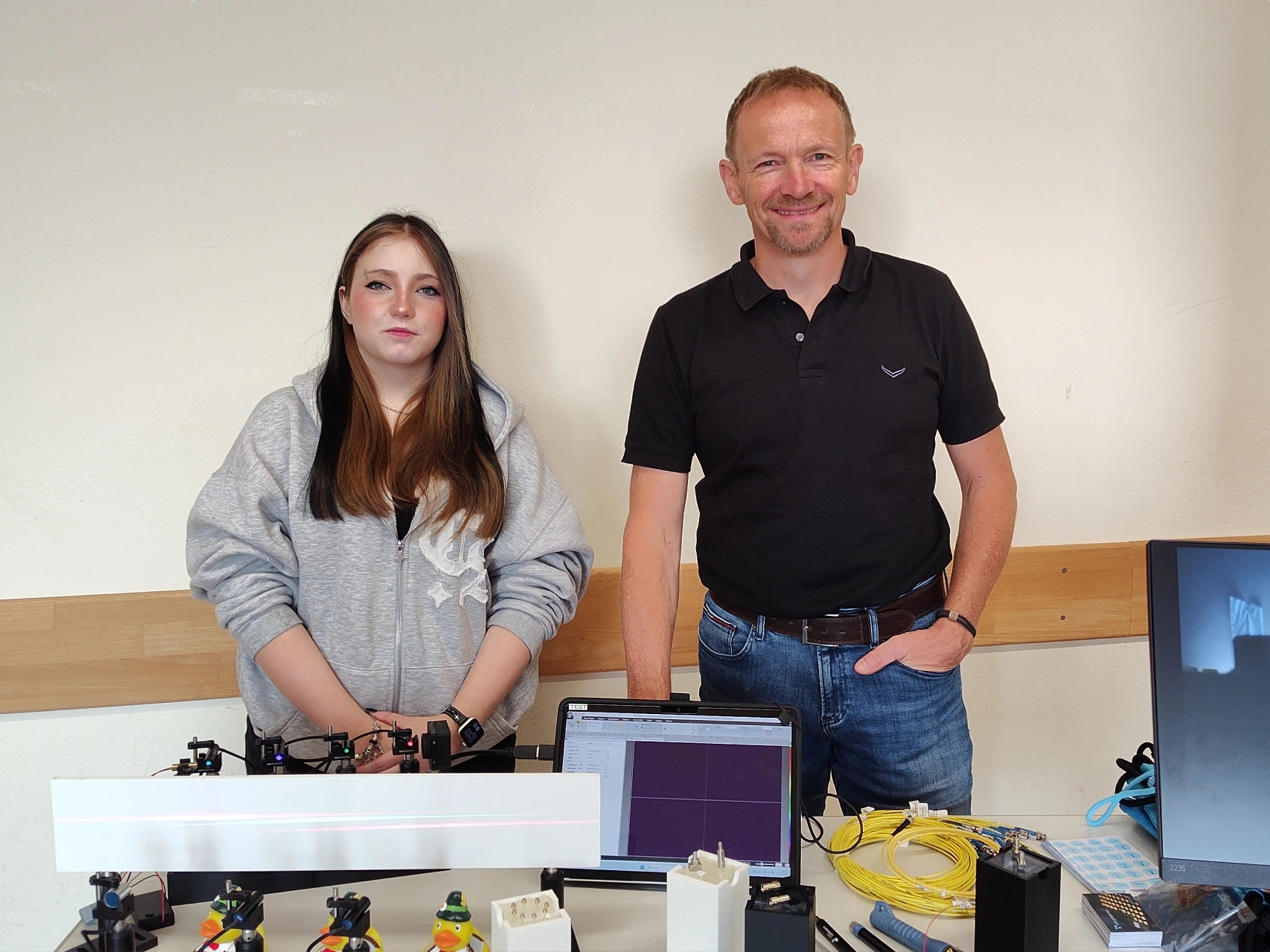 Ein Ausbilder und eine Auszubildende lächeln gemeinsam bei IMM Photonics.